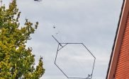 Helikopter met een groot meetinstrument laag over Bakkeveen.